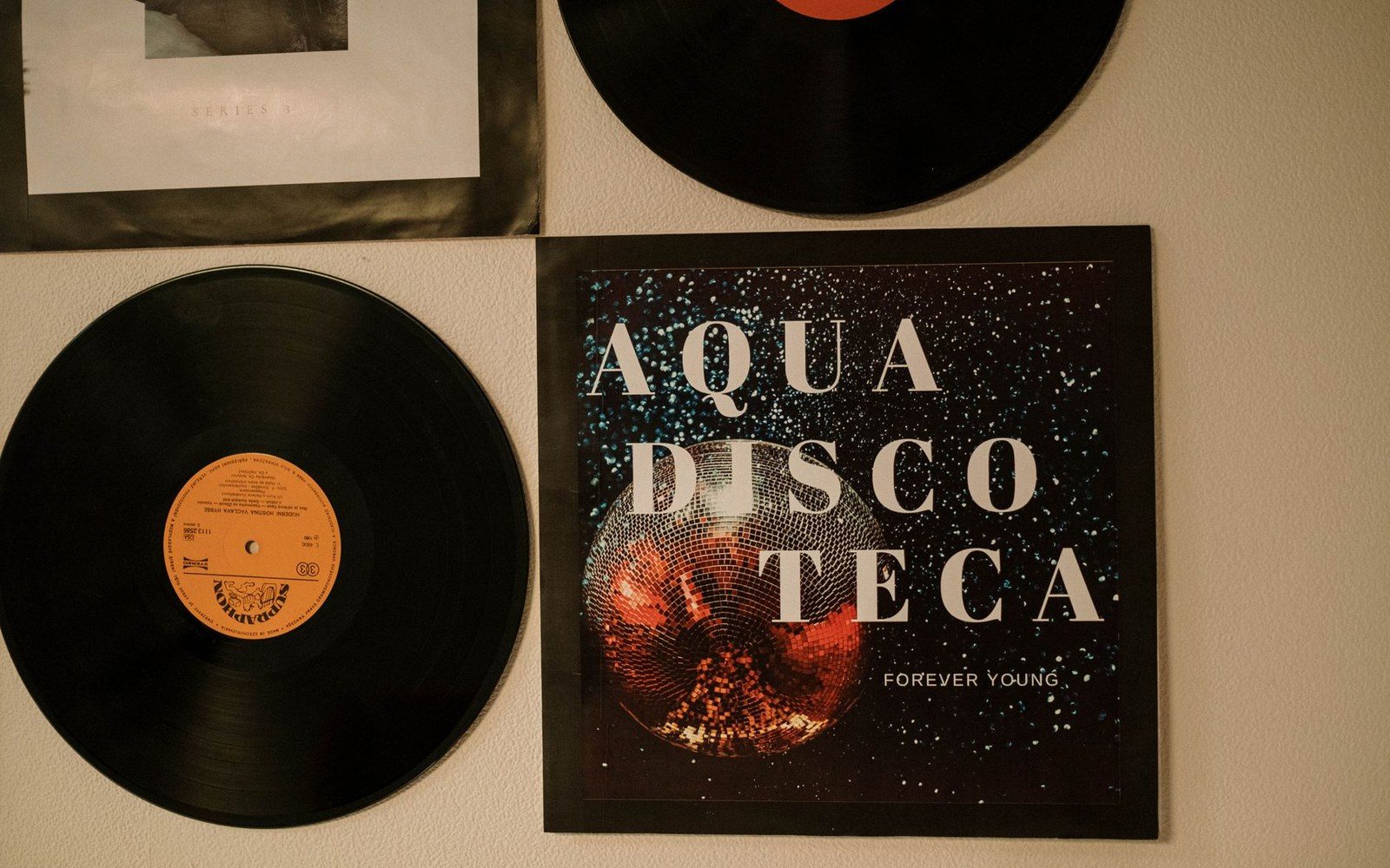 Stack of certified gold and platinum discs mounted on a white wall, label text visible
