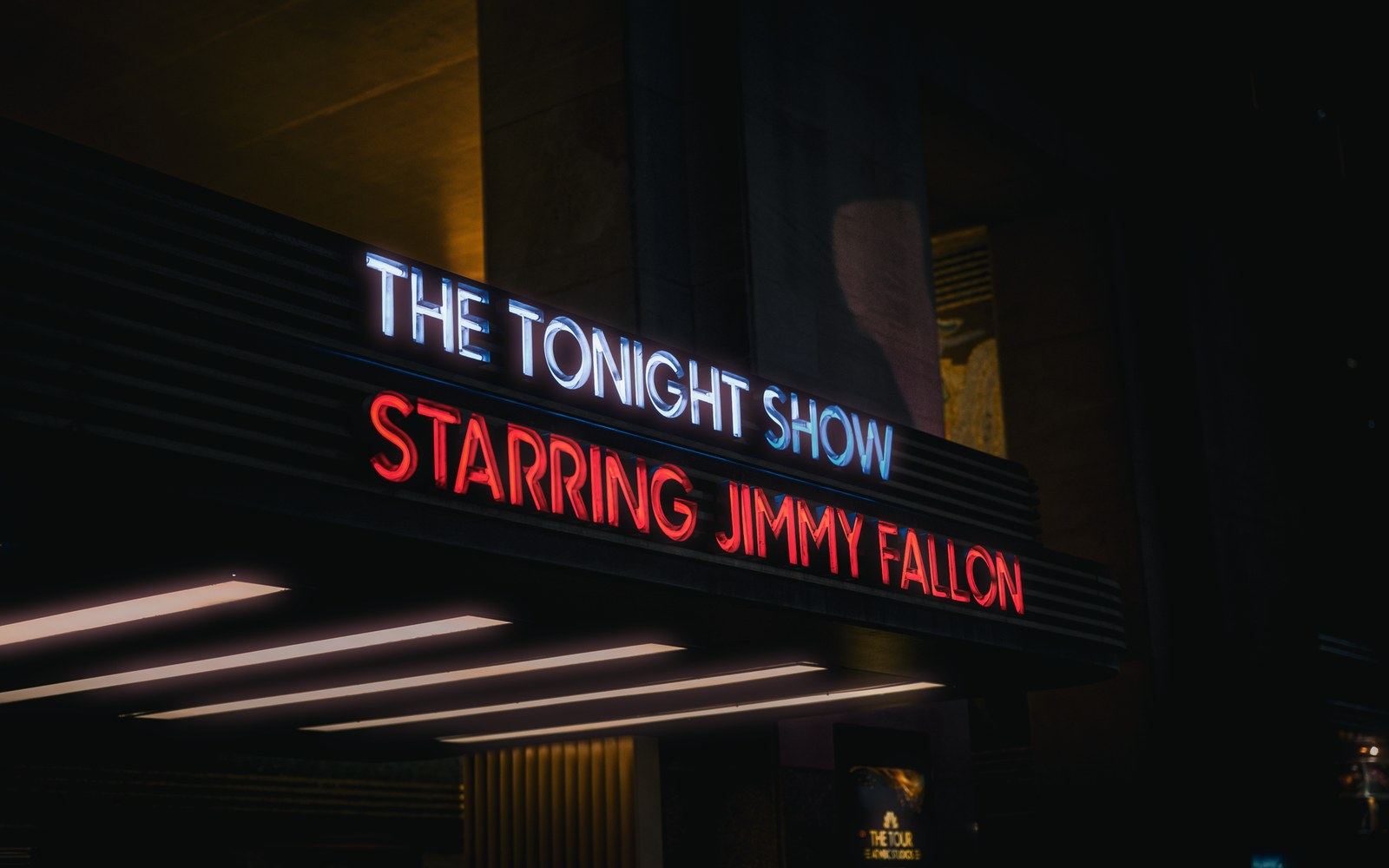 Illuminated marquee sign reading "The Tonight Show Starring Jimmy Fallon" at night